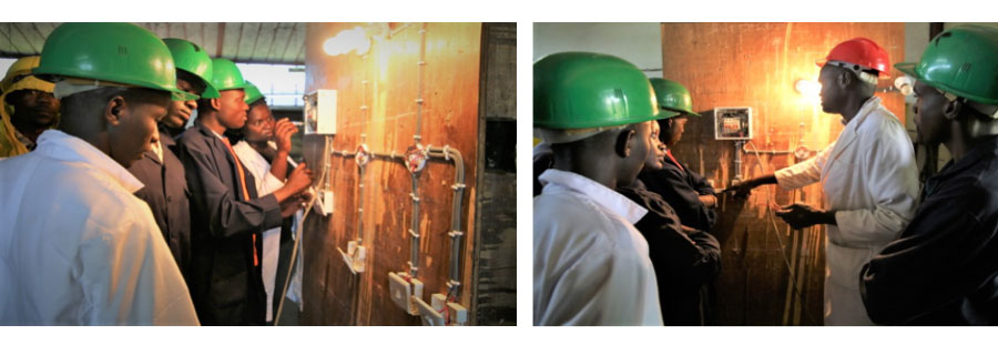 Basic-level electrical installation students during a practical lesson on the Domestic wiring system.  The students following-up an illustration from their trainer on how the system works 