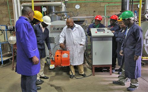 Mr. Antony Munuha showing intermediate level students how a Gas-fired boiler operates